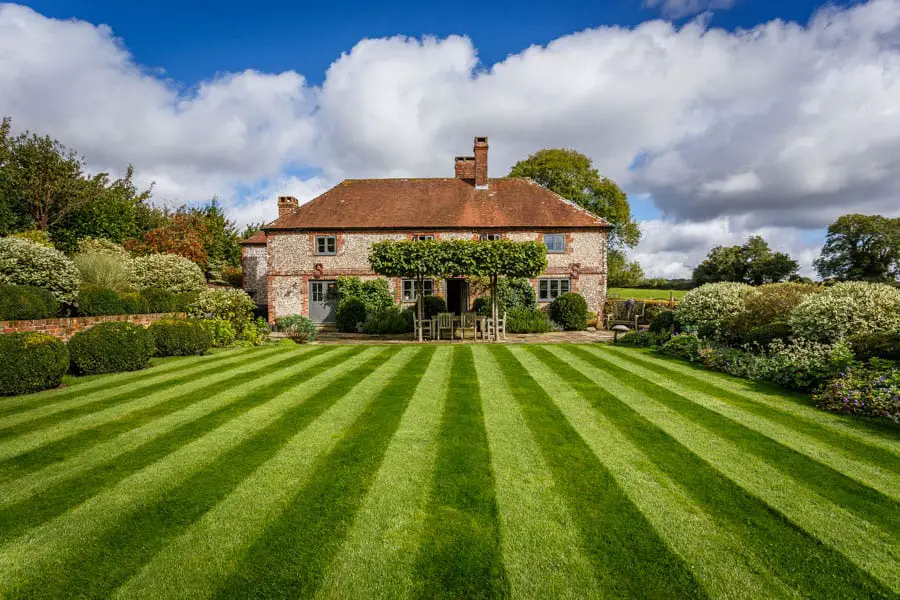 Photograph of the grounds and side elevation of a country house